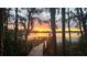 Enchanting sunset view over the lake from a wooden dock, surrounded by lush trees and Spanish moss at 2908 Lee Shore Loop, Orlando, FL 32820