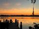 Calm lake view at sunset from the dock with Adirondack chairs, enhanced by Spanish moss draped from trees at 2908 Lee Shore Loop, Orlando, FL 32820