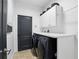 Laundry room featuring a black washer and dryer set, white cabinets and a countertop at 2908 Lee Shore Loop, Orlando, FL 32820