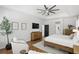 Cozy main bedroom featuring a wooden bed frame, tray ceiling, ceiling fan and two chairs for relaxing at 2908 Lee Shore Loop, Orlando, FL 32820