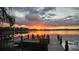 Stunning sunset over the lake featuring a private dock with Adirondack chairs, perfect for relaxation and enjoying the view at 2908 Lee Shore Loop, Orlando, FL 32820