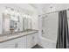 Bright bathroom with double sink vanity, granite countertop, and a shower-tub combo at 2913 Wilshire Rd, Clermont, FL 34714