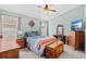 Cozy bedroom featuring a comfortable bed, dresser, and soft natural light from the window at 2913 Wilshire Rd, Clermont, FL 34714