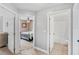 Hallway showing doorways into a bedroom with a queen sized bed and a full bathroom at 2913 Wilshire Rd, Clermont, FL 34714