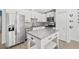 Modern kitchen featuring white cabinets, granite countertops, a kitchen island, and stainless appliances at 2913 Wilshire Rd, Clermont, FL 34714