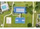 Aerial view featuring well-maintained tennis and basketball courts, with a sand volleyball court and green spaces at 2913 Wilshire Rd, Clermont, FL 34714