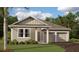 Charming single-story home with a two-car garage, neutral siding, and lush landscaping at 30124 Misty Pines Road, Mount Dora, FL 32757