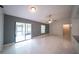 Living area featuring white tile floors, a ceiling fan, and slider door at 3149 Quail Dr, Deltona, FL 32738