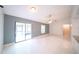 An open floor plan living room featuring tiled floors, a ceiling fan, and sliding glass doors at 3149 Quail Dr, Deltona, FL 32738