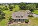 Aerial view of a charming two-story home with a front porch, surrounded by lush green lawns and mature trees at 3201 Oaklea Dr, Deland, FL 32720