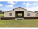 Front view of a well-kept barn with a bright exterior, clean entryway and green lawn at 3201 Oaklea Dr, Deland, FL 32720