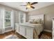 Bright bedroom with hardwood floors, white furniture, and large windows with white curtains at 3201 Oaklea Dr, Deland, FL 32720