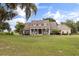 Charming front of the home with lush landscaping and covered porch, set on a spacious lot under a beautiful sky at 3201 Oaklea Dr, Deland, FL 32720