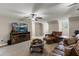 Cozy living room featuring a comfortable leather set, ceiling fan, and media center with a large screen television at 3201 Oaklea Dr, Deland, FL 32720