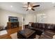 Spacious living room featuring hardwood floors, a large television, and a comfortable leather sectional at 3201 Oaklea Dr, Deland, FL 32720