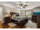 Spacious main bedroom with a ceiling fan, dark wood furniture, and plush bedding at 3201 Oaklea Dr, Deland, FL 32720