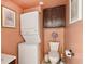 Cozy bathroom featuring a stacked washer and dryer, toilet, and cabinet at 3312 Se 6Th St, Ocala, FL 34471