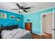 This charming bedroom boasts bright blue walls, a modern ceiling fan, and stylish decorations at 3312 Se 6Th St, Ocala, FL 34471