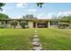 Charming single-story home with a well-manicured lawn and stepping stone pathway leading to the front door at 3312 Se 6Th St, Ocala, FL 34471