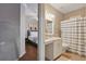 View from the hallway into a bathroom featuring a bathtub and a bedroom featuring a full-sized bed at 405 Courtlea Park Dr, Winter Garden, FL 34787