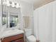 Well-lit bathroom featuring a clean white shower curtain and cherrywood cabinets at 405 Courtlea Park Dr, Winter Garden, FL 34787