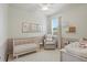 Charming Bedroom with a white crib, comfortable armchair, and soft lighting at 405 Courtlea Park Dr, Winter Garden, FL 34787