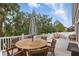 Cozy deck with dining table, umbrella, lounge area, and serene backyard views at 405 Courtlea Park Dr, Winter Garden, FL 34787
