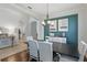 Dining room featuring a modern table and chairs, teal accent wall with neutral artwork and hardwood floors at 405 Courtlea Park Dr, Winter Garden, FL 34787