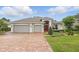 Charming single-story home with a well-manicured lawn, brick driveway and two car garage at 405 Courtlea Park Dr, Winter Garden, FL 34787