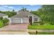 Aerial view of attractive single-story home with brick driveway and manicured lawn with mature trees at 405 Courtlea Park Dr, Winter Garden, FL 34787