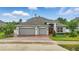 Attractive home with a brick driveway, two-car garage, a well-maintained lawn, and beautiful landscaping at 405 Courtlea Park Dr, Winter Garden, FL 34787