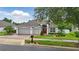 Beautiful front exterior of a well-maintained home with a brick driveway, two-car garage, and neatly landscaped yard at 405 Courtlea Park Dr, Winter Garden, FL 34787