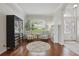 Bright living room with hardwood floors, plush chairs, large windows with shutters, and elegant decor at 405 Courtlea Park Dr, Winter Garden, FL 34787