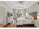 Serene main bedroom featuring tray ceilings, hardwood floors, and a large window at 405 Courtlea Park Dr, Winter Garden, FL 34787