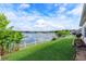 Lush backyard with a picturesque lake view, beautifully landscaped and framed by a white picket fence at 4642 Waterside Pointe Cir, Orlando, FL 32829