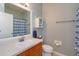 Bathroom features a sink, mirror, toilet, cabinet, and a shower with a blue striped shower curtain at 4642 Waterside Pointe Cir, Orlando, FL 32829
