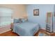 Cozy bedroom featuring a plush bed with blue bedding and a bright window with a view to the outdoors at 4642 Waterside Pointe Cir, Orlando, FL 32829