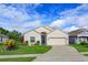 Charming single-story home featuring a well-manicured lawn and two car garage under a sunny sky at 4642 Waterside Pointe Cir, Orlando, FL 32829