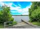 Scenic lake view with a wooden dock and lush greenery, providing serene waterfront access at 4642 Waterside Pointe Cir, Orlando, FL 32829
