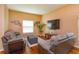 Cozy living room with comfortable seating, a large TV, and natural light from the window at 4642 Waterside Pointe Cir, Orlando, FL 32829