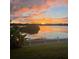 Picturesque water view at sunset with lush greenery and a charming white picket fence at 4642 Waterside Pointe Cir, Orlando, FL 32829