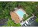 An aerial view showing the large pool, hot tub, sun deck, a building, and parking in a serene, tree-lined community at 620 Glenwood Ct # 79, Altamonte Springs, FL 32714