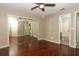 Bedroom featuring hardwood floors, lighted ceiling fan, mirrored closet doors, and a view to the bathroom at 620 Glenwood Ct # 79, Altamonte Springs, FL 32714
