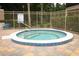 Inviting hot tub with a blue and white tile border, set on a beautiful multicolor brick patio, surrounded by a secure fence at 620 Glenwood Ct # 79, Altamonte Springs, FL 32714