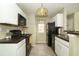 Galley kitchen with black appliances, white cabinetry, and tile flooring at 620 Glenwood Ct # 79, Altamonte Springs, FL 32714