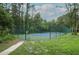 Well-maintained tennis court with green and blue surface, enclosed by a tall, dark green chain-link fence amidst lush greenery at 620 Glenwood Ct # 79, Altamonte Springs, FL 32714