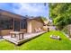 Backyard featuring a wooden deck, a small fire pit, and lush green lawn. The yard is surrounded by a wooden fence at 638 Boniview Ln, Altamonte Springs, FL 32714