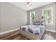 Cozy bedroom with two windows, ceiling fan, and a full-sized bed with a unique headboard at 685 Mayo Ave, Maitland, FL 32751