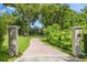 Long winding brick driveway leads to a private estate surrounded by lush greenery and mature trees at 685 Mayo Ave, Maitland, FL 32751