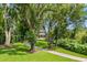 Beautiful home surrounded by mature trees and lush landscaping along a paver driveway at 685 Mayo Ave, Maitland, FL 32751